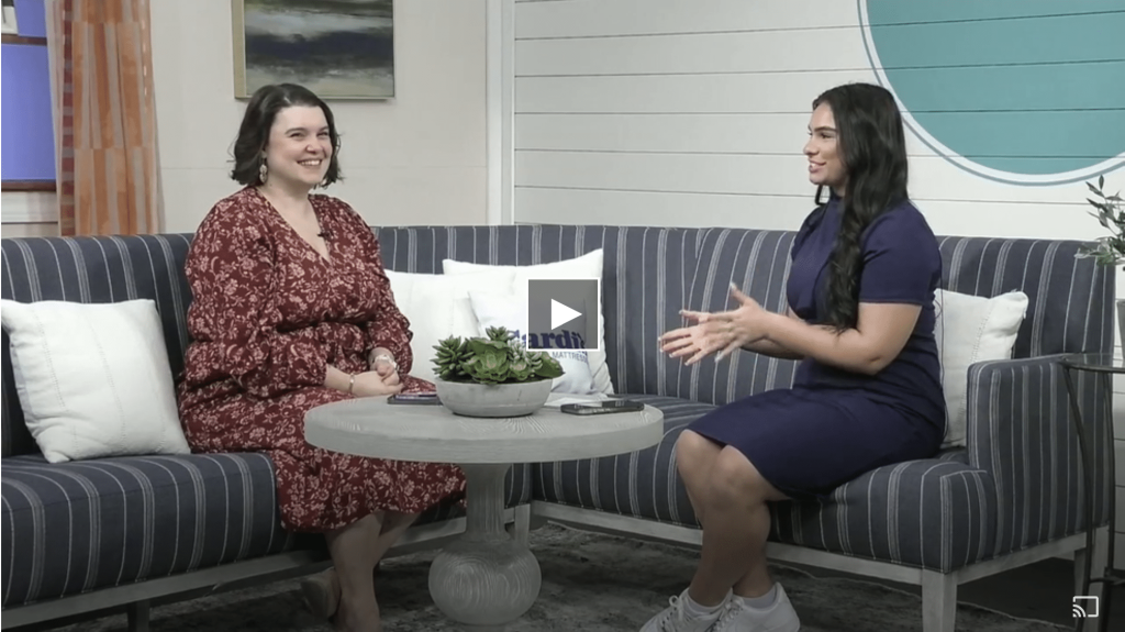Two women engaged in conversation on a striped couch, discussing kitchen design and renovation options from Dartmouth Building Supply.