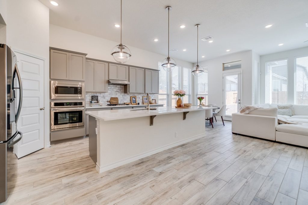 Modern kitchen with gray cabinets, stainless steel appliances, and a spacious island, featuring a bright, airy atmosphere ideal for home renovations and design inspiration.